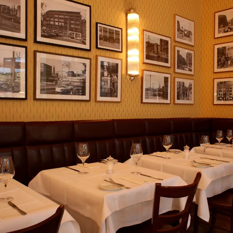 Gutbürgerliche Einrichtung mit lederbezogenen Sitzen, gelben Wandtapeten und historischen Fotos im Hackescher Hof, einem der besten deutschen Restaurants in Berlin