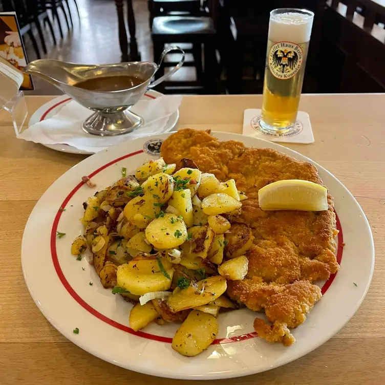 Paniertes Schnitzel mit Bratkartoffeln, Zitrone, Bratensauce und einem Glas Kölsch im Gaffel Haus Berlin an der Friedrichstraße, einem der besten deutschen Restaurants in Berlin