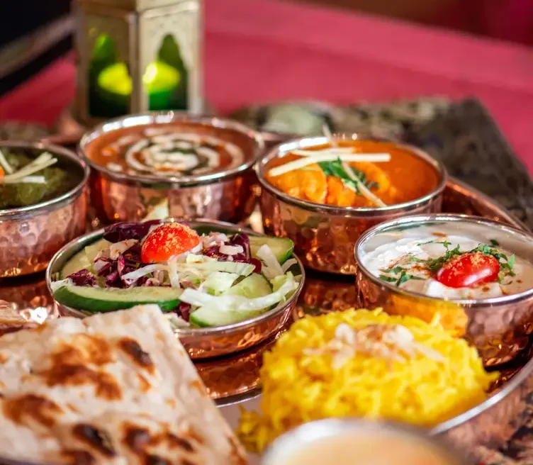 Curry-Varianten in Kupferschalen serviert im Mera Masala – einem der besten indischen Restaurants in Frankfurt.