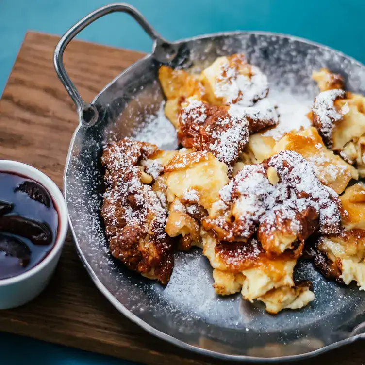 Kaiserschmarrn mit Puderzucker in silberner Pfanne bei Einstein Unter den Linden, einem der besten österreichischen Restaurants in Berlin.